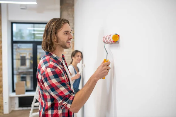 Pareja joven pintando la pared en su nueva casa —  Fotos de Stock