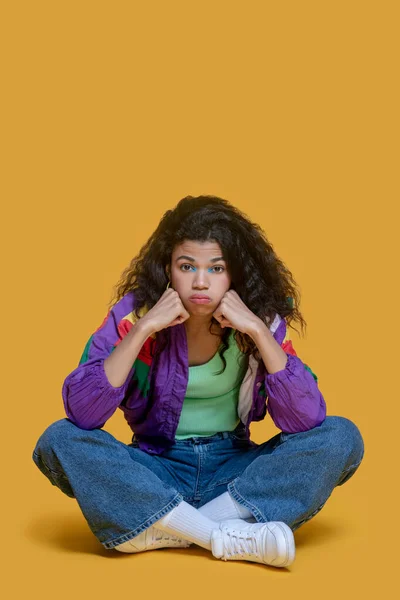 Ganska mörkhårig ung flicka i jeans ser ledsen ut — Stockfoto