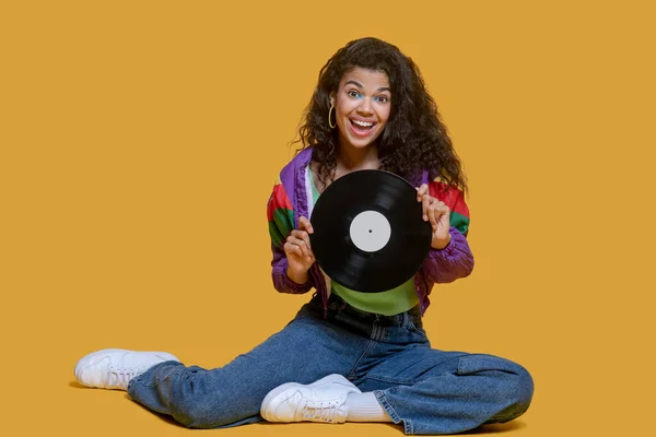 Young dark-haired young girl holding a record in her hands — Stock Photo, Image