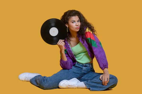 Sweet dark-haired young girl holding a vinyl record — Stock Photo, Image