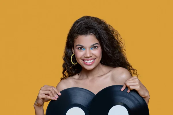 Cute dark-haired young girl holding records and feeling good — Stock Photo, Image