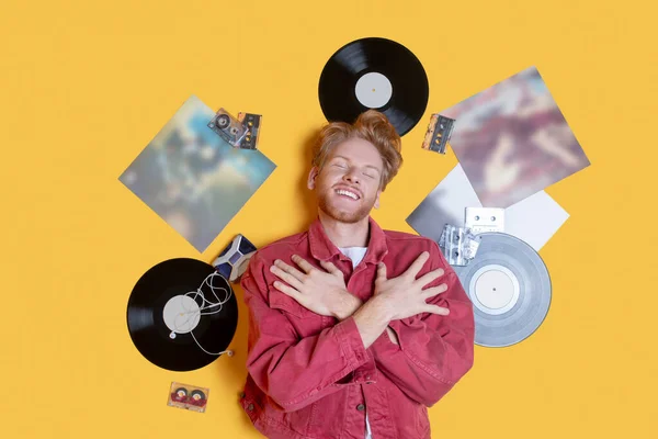 Ginger smiling man lying near the records and feeling good — Stock Photo, Image