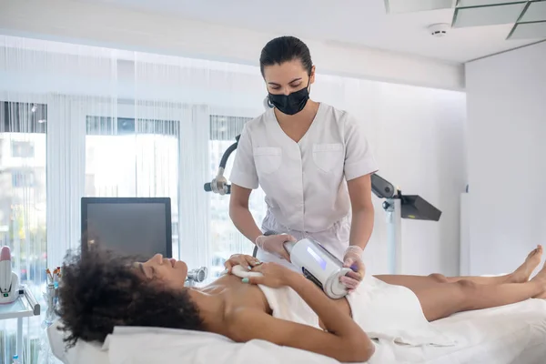 Chica joven y médico durante el procedimiento cosmético — Foto de Stock