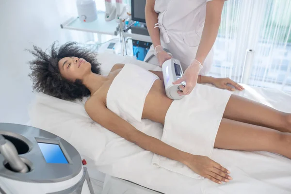 Mulher sorridente durante o procedimento de cuidados com o corpo médico — Fotografia de Stock