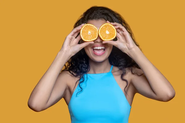 Mujer joven de cabello oscuro con naranja en las manos — Foto de Stock