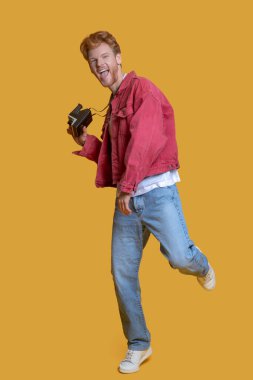 Kızıl saçlı, sakallı, yaşlı kameralı genç adam mutlu.