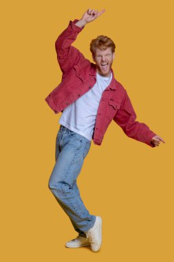 Kızıl saçlı, sakallı, kırmızı ceketli genç adam heyecanlanıyor.