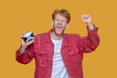 Genç, sakallı, yakışıklı, kırmızı ceketli, yaşlı bir oyuncu.