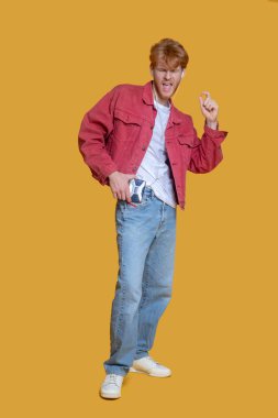 Genç, sakallı, yakışıklı, yaşlı oyuncu görünümlü adam eğleniyor.