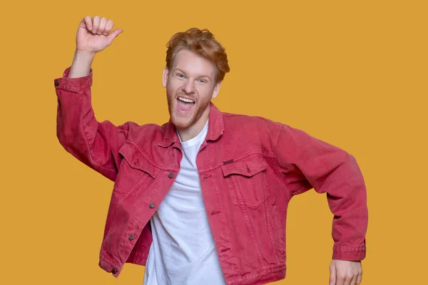 Red-haired bearded young man in red jacket feeling excited — Stock Photo, Image
