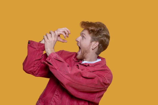 Red-haired bearded young man in red jacket having fun — Stock Photo, Image