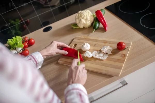 Nært bilde av husmor som klipper grønnsaker på kjøkkenet – stockfoto