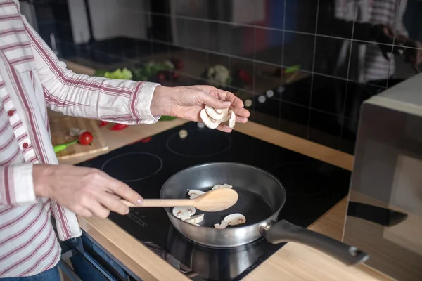 Menutup gambar seorang wanita mengaduk makanan di atas wajan — Stok Foto