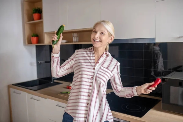 Блондинка-домохозяйка веселится на кухне и чувствует себя счастливой — стоковое фото
