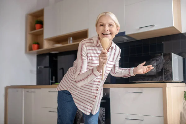 Rubia ama de casa divertirse en la cocina y sonriendo — Foto de Stock