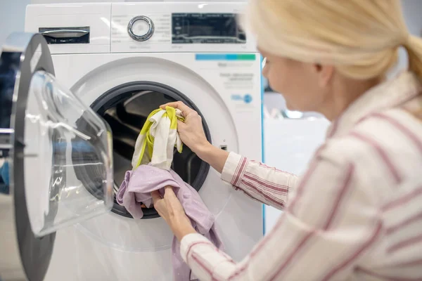 Ibu rumah tangga perempuan menempatkan pakaian ke dalam mesin cuci — Stok Foto