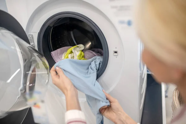 Ibu rumah tangga perempuan menempatkan pakaian ke dalam mesin cuci — Stok Foto