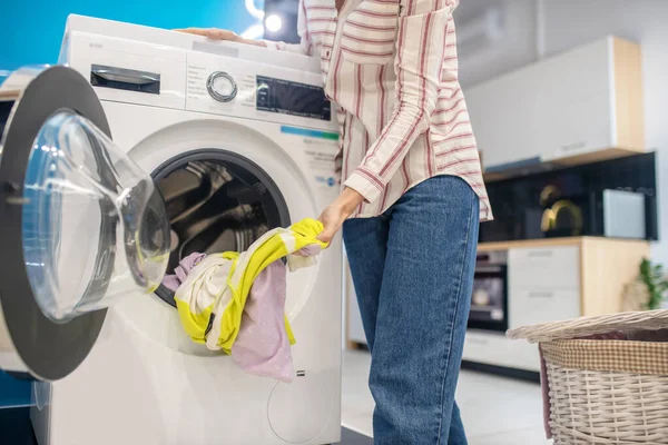 Çamaşır makinesinden kıyafet alan sarışın kadın. — Stok fotoğraf