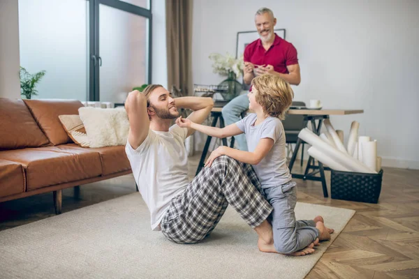 Diversa familia haciendo ejercicios en casa y sintiéndose bien —  Fotos de Stock