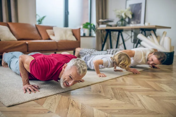 Två män och deras son gör armhävningar och ser bra ut — Stockfoto