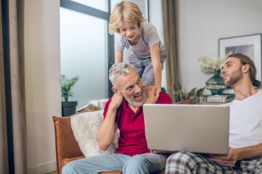 Sevimli sarışın çocuk ve ailesi birlikte vakit geçiriyorlar.