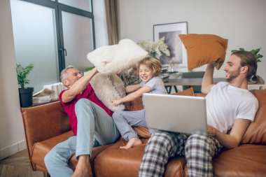 Yakışıklı sarışın çocuk ve iki erkek yastık kavgası.