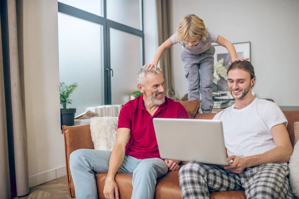 Netter blonder Junge und seine Familie verbringen Zeit zu Hause — Stockfoto