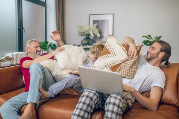 Sevimli sarışın çocuk ve iki erkek yastık kavgası ve neşeli hissetmek