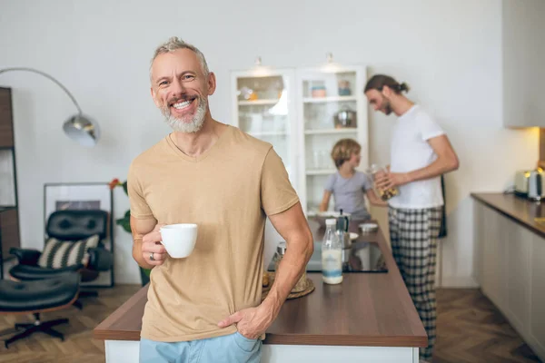 Gråhårig man som dricker morgonkaffe och mår bra — Stockfoto