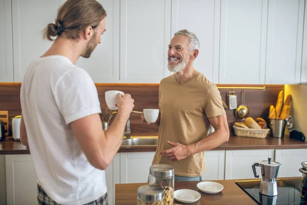 Couple homosexuel prenant le petit déjeuner ensemble à la maison et se sentant bien — Photo