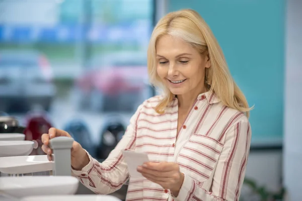 Mujer rubia eligiendo productos para la cocina y buscando n — Foto de Stock