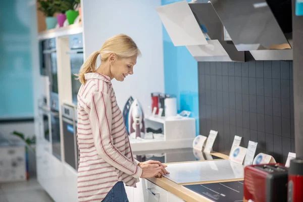 Loira cliente feminino escolher bens em um showroom — Fotografia de Stock