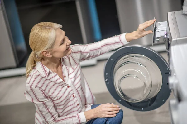 Kundin im gestreiften Hemd wählt Waschmaschine im Megastore — Stockfoto