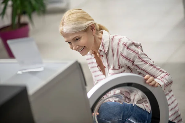 Mujer eligiendo una lavadora en una sala de exposición —  Fotos de Stock
