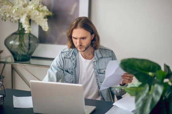 Jongeman in jeans shirt aan het werk op een laptop — Stockfoto