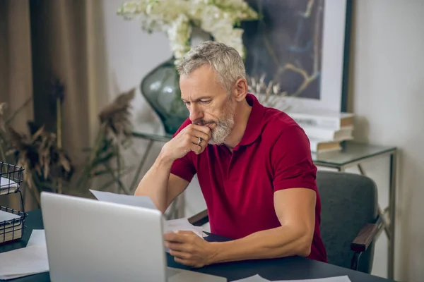 Siwy mężczyzna siedzi przy laptopie i pracuje — Zdjęcie stockowe