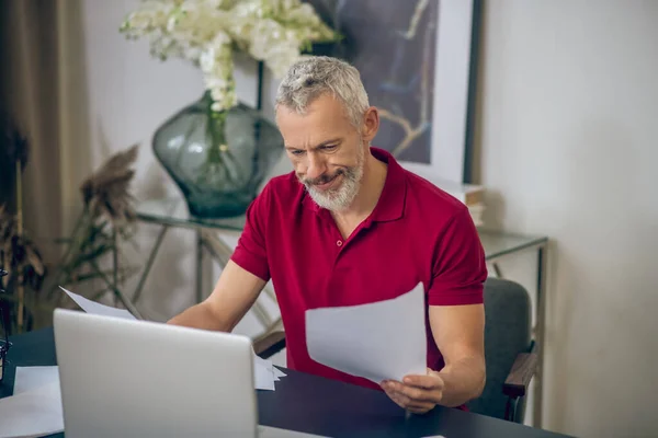 Homem de cabelos grisalhos sentado no laptop e trabalhando — Fotografia de Stock