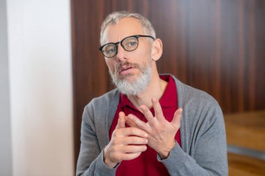 Gözlüklü, kendine güvenen bir adam durumu açıklıyor.