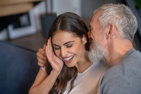 Grey haired man saying compliments to his young spouse — Stock Photo, Image