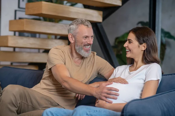 Homem maduro feliz tocando abdômen de sua jovem esposa grávida — Fotografia de Stock