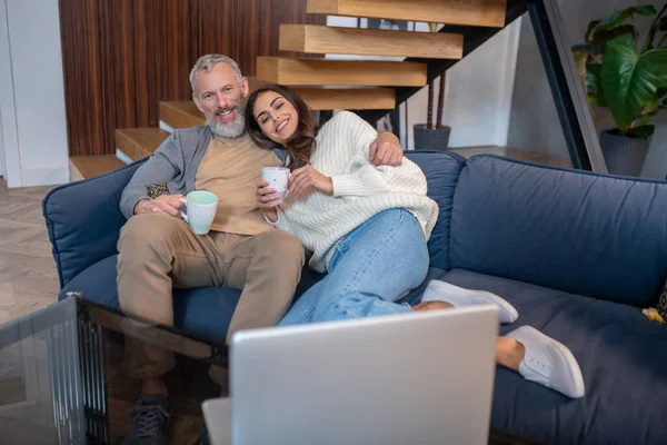 Супружеская пара, сидящая на диване и расслабленная — стоковое фото