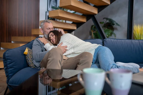 Grey-haired man hugging his wife and feeling comfortable — Stock Photo, Image