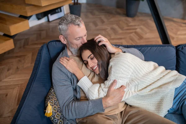Homem de cabelos grisalhos abraçando sua esposa e se sentindo confortável — Fotografia de Stock