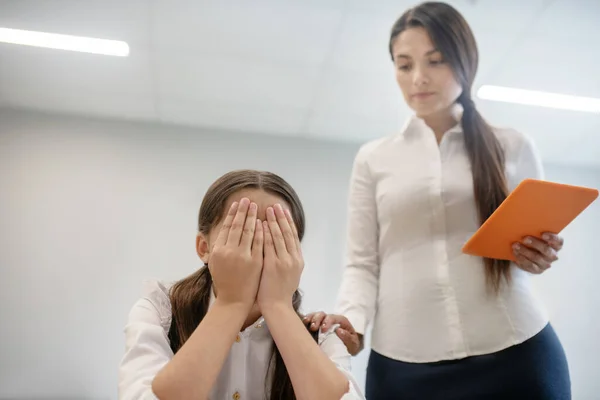 Chica ocultar la cara y el maestro con la tableta — Foto de Stock