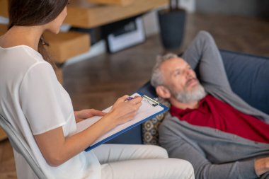 Beyaz saçlı adam profesyonel psikoterapistle konuşuyor.