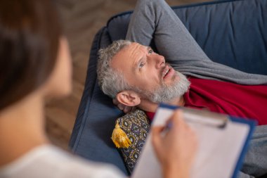 Terapistle psikolojik sorunları üzerinde çalışan bir adam.