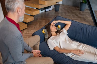 Başı ağrıyan bir kadınla ilgilenen adam.