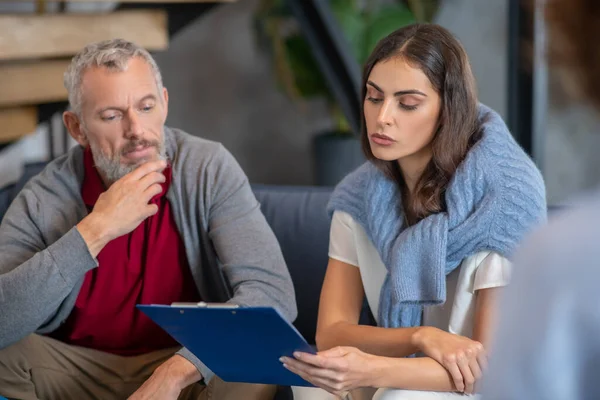 Hombre y mujer revisando su informe de terapeuta — Foto de Stock