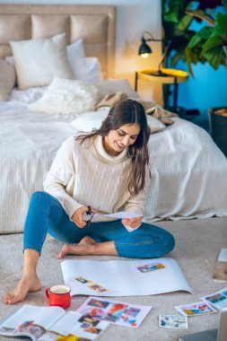 Dergilerden tabanca kesen ve dilek listesi hazırlayan hoş bir genç kadın.