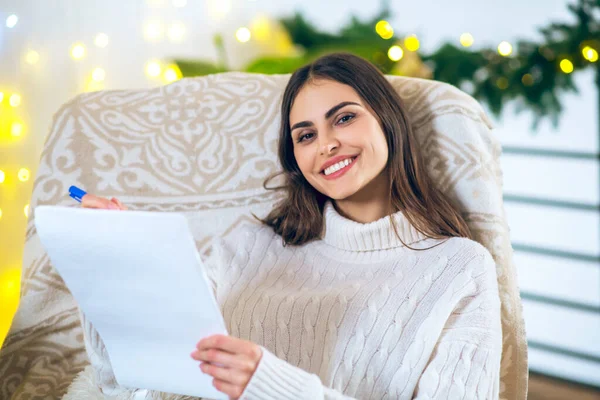 Carino giovane donna rendendo la sua wishlist e cercando contento — Foto Stock